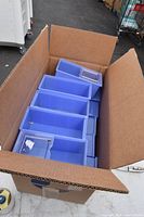 Photo of 20 blue plastic small parts bins stacked inside a large cardboard box, showing the quantity and general condition of the bins.