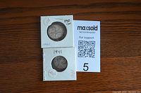 Two Canadian quarters, 1940 and 1941, each in white coin holders.