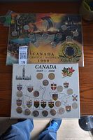 Two Canadian coin collector sets displayed on boards with coins and provincial symbols, marks the 1867-1992 period and 1999 Millennium.