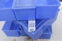 Stack of multiple blue plastic parts bins with translucent hinged lids, showing quantity and overall condition.