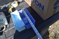 Photo showing two plastic parts bins, one light blue and one dark blue, with a ruler indicating size about 10 inches long