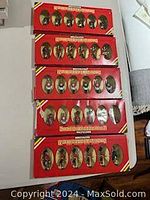 Five boxes with clear plastic windows showing hand painted metal soldier figures inside red boxes marked 'Britains British Regiments'.