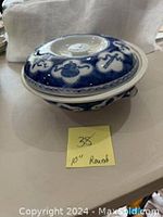 Side view of large blue and white casserole dish with lid, showing 10 inch round measurement note.