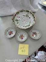 Top-down photo of the ceramic strawberry strainer dish and three small side condiment dishes grouped together showing size and design details.