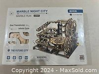 Front of box showing assembled puzzle with mechanical gear and marble run details with brand and model name.
