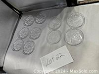 Photo showing 10 clear round glass coasters arranged on a white background with lot number card; 6 with one design and 4 with a different design visible.