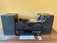 Overall shot showing both Mystere speakers, Akai cassette deck, Sony CD changer, microphone and cables on wooden surface.