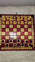 Top-down view of the chess board showing all pieces arranged in starting position with red and cream squares