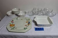Full view of 10-piece lot showing five unbranded clear glass bowls, three white Corning Ware casseroles, 8x8 white casserole dish, floral octagonal ceramic plate and Mikasa platter.