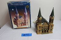 Santa's Workbench St. Augustine's Cathedral Christmas village piece alongside original box, showing front and key details of the cathedral model.