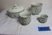 Mikasa Ultra Ceram round casserole with lid and three floral ceramic vases arranged on white cloth, showing floral design and overall condition.