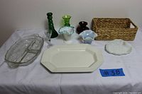 Full lot view with various small vases, dishes, and baskets on a white cloth.