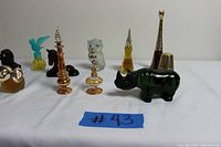 Shows front row of Avon perfume bottles including owl, rhino, and other animal figures and novelty shapes in multiple colors.