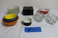 All items arranged grouped on white surface showing full set including measuring cups, ashtrays, small bowls, dessert plates, and metal box.