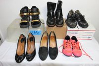 All six pairs of shoes displayed on a table, showing varied styles including boots, sneakers, and heels.