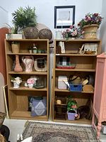 Front view of two wooden book shelves filled with various decorative items for size reference. Shelves have adjustable shelf heights.