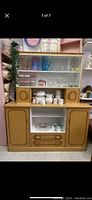 Front view of vintage wooden kitchen cabinet with glass display section on top, lower wooden storage cabinets with two doors and two drawers, decorative Art Deco design details.