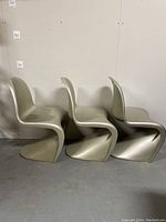 Three Verner Panton style mid-century modern chairs in silver color with visible wear
