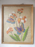 Full view of the framed embroidery artwork showing two colorful butterflies and flowers in a wooden frame.