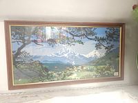 Full view of the framed vintage cross stitch landscape artwork.