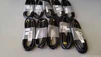 Ten black DisplayPort cables coiled and secured with plastic straps, showing full lot overview.