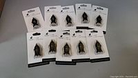 Photo of 10 black USB car chargers in original white blister packaging with hanging tabs, arranged in 2 rows.