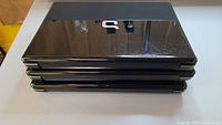 Stack of three black laptops with Compaq logo on lids.