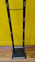 Front view of double sided Monster display rack showing hooks and base branding.