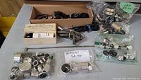Overall lot contents including audio knobs, cables, belts, and mounted Garrard spindle box