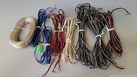 Full view of seven bundles of various colors and gauges of speaker wire coiled and tied