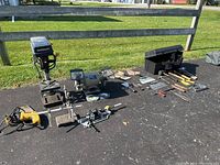 Photo showing all items in lot arranged outdoors including drill presses, bench grinders, hand tools and clamps.