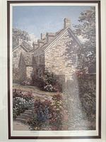 Close-up photo of the print inside the frame showing the detailed pastoral scene including stone house and garden with flowers.