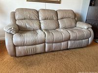Front view of taupe leather and PVC three-seat reclining sofa