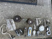 Top view of assorted boat marine hardware including two winches, pulleys, cleats and a Ronstan branded pulley in bag
