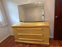 Front view of the 6-drawer dresser and mirror showing the blonde mahogany finish and brass handles with wood accents.