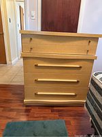 Front view of the mid-century high boy dresser showing four lower drawers with horizontal pulls and two upper drawers with knob pulls.