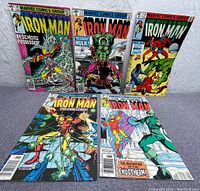 Group photo showing five Iron Man vintage comic books with price 40 cents each, arranged in two rows on a neutral background.