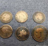 Top side view showing front of 6 old Canadian coins with portraits and inscriptions.