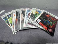 Ten Brightest Day comic books fanned out on a flat surface showing colorful covers including Aquaman and Martian Manhunter.