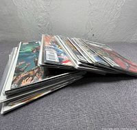 Stack of comic books in protective sleeves viewed from an angle showing multiple issues.