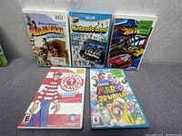 Five game cases including Madagascar Kartz, Nintendo Land, Hot Wheels Racing, Where's Waldo?, and Super Mario 3D World