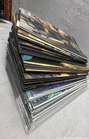 Stack of 60 comic books showing edges with varying condition and some in protective sleeves
