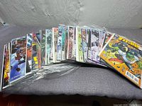 Lot of 22 DC Titans comic books laid out side by side on a surface, each in plastic protective sleeves.