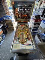 Front view of entire pinball machine showing backbox and playfield under glass