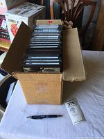 Box filled with DVDs stacked inside, showing DVD spines at the top of the box