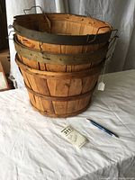 Photo of three wooden bushel baskets stacked showing size and condition