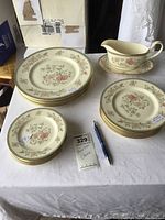 Complete partial china set showing all plate types stacked and gravy boat with underplate to the side.