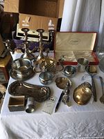 Photo showing multiple silverplate items including candlesticks, bowls, creamer, and serving trays.