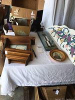 Overview photo showing all wood items on a table including shelves, plaques, wall decor, and hooks