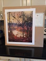 Full view of unframed Tom Thomson Northern River fine art print mounted on cardboard with certificate of authenticity visible
